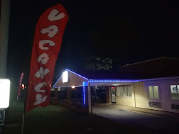 Red Crown Inn exterior at dusk with vacancy sign lit